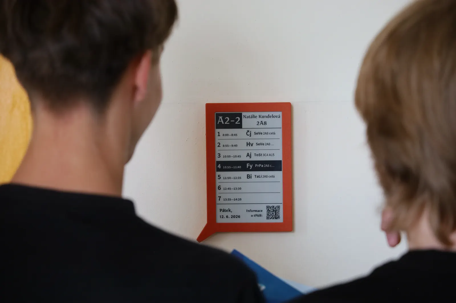Studenti gymnázia u digitálního rozvrhu na chodbě školy